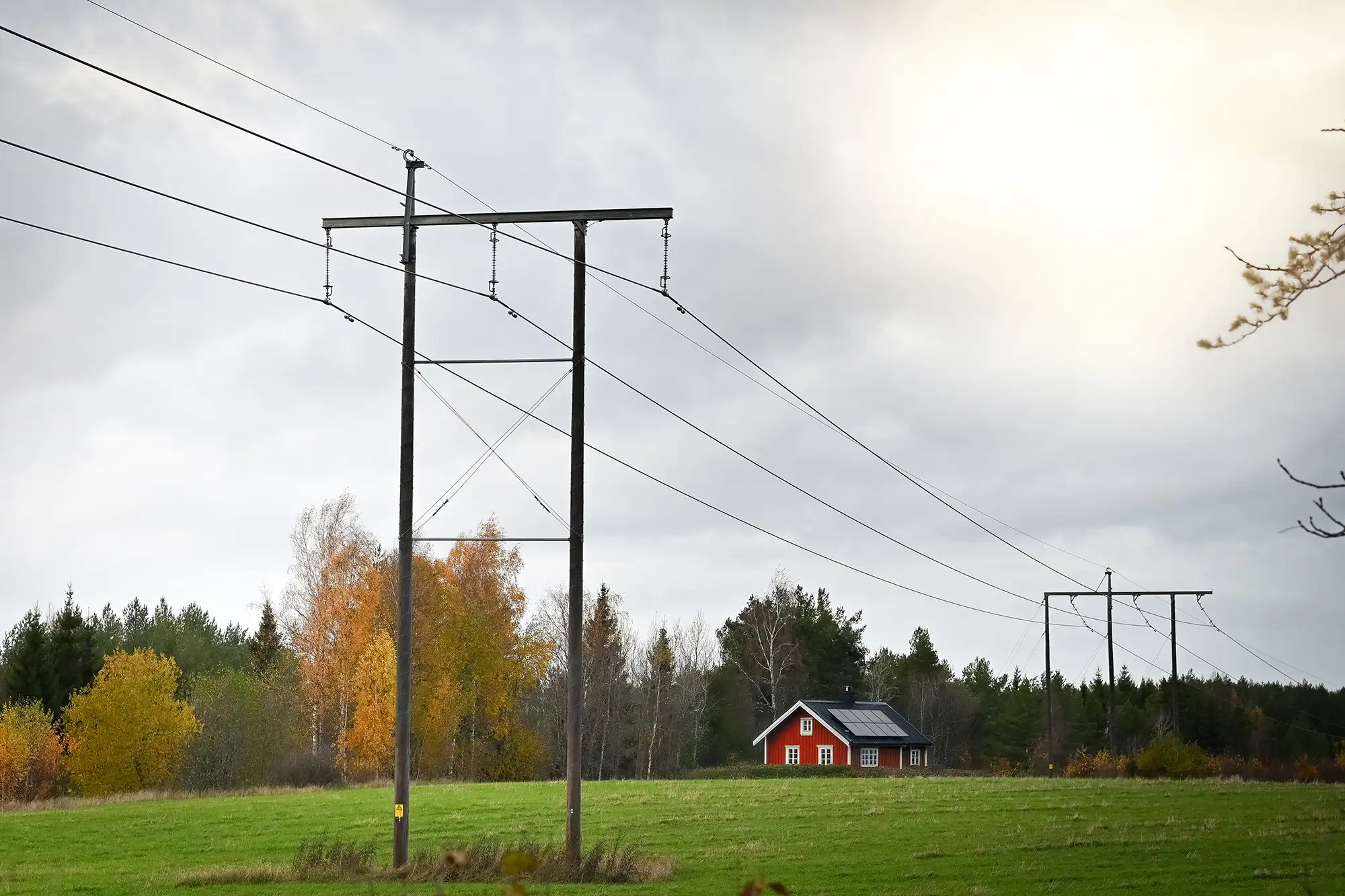 Solceller från Sesol på en stuga i bakgrunden av en elledning